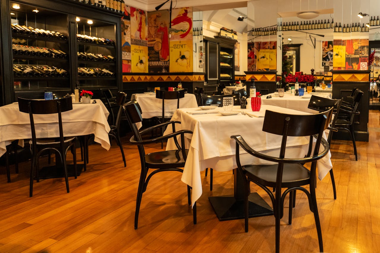 Chic dining space in Zagreb with neatly set tables and a prominent wine display, perfect for an upscale dining ambiance.